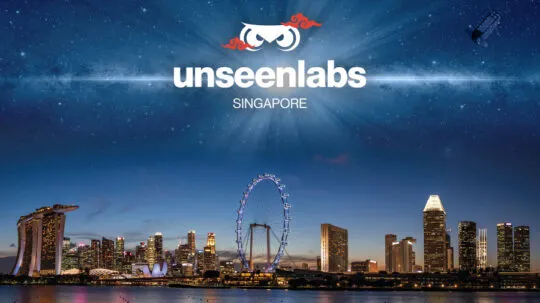 A stunning composite image of the Singapore skyline at dusk, featuring the iconic Marina Bay Sands hotel, the Singapore Flyer, and illuminated skyscrapers reflecting on the calm waters. Above the city, the Unseenlabs logo with stylized owl eyes and red decorative accents is prominently displayed, accompanied by the word "SINGAPORE" beneath it. A satellite orbits in the starry night sky, symbolizing the company's expansion and presence in the region. The composition blends urban sophistication with space technology, highlighting Unseenlabs' role in maritime surveillance and innovation.