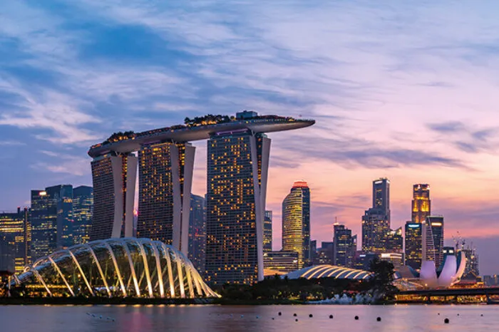 Singapore skyline at dusk, featuring Marina Bay Sands, Gardens by the Bay, and the illuminated cityscape reflecting on the water. © Unseenlabs