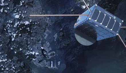 A high-resolution image of an Unseenlabs satellite orbiting Earth, showcasing its cubic design, solar panels, and extended antennas for radio frequency (RF) detection. The satellite is positioned above a coastal city with harbors and waterways visible below, emphasizing its role in maritime surveillance. The satellite's shadow is cast on its metallic surface, while the Earth’s surface, scattered with clouds, provides a striking contrast. This image highlights Unseenlabs’ space-based intelligence capabilities in tracking and monitoring vessels across global waters.