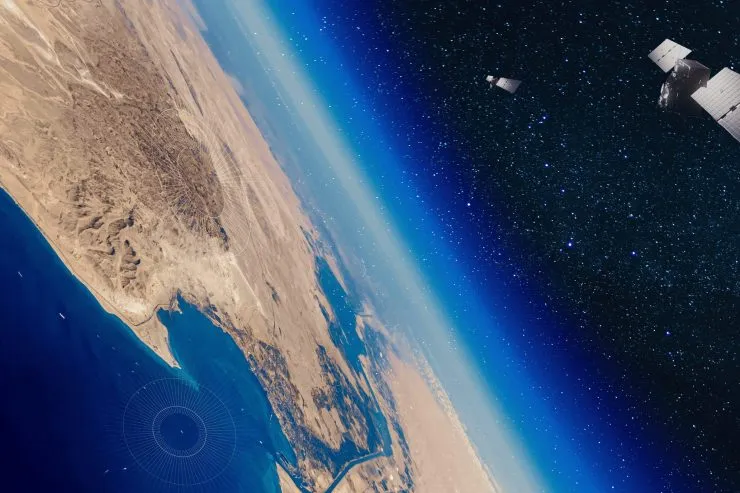 View of Earth from space showing the Red Sea region, including the Gulf of Suez and surrounding desert, with two satellites in orbit collecting RF data from ships at sea and coastal zones.